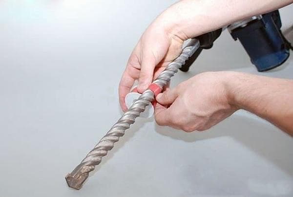  Minh họa kỹ thuật sử dụng mũi khoan tường với máy khoan búa, nhấn mạnh việc đeo kính bảo hộ và thoát bụi định kỳ.