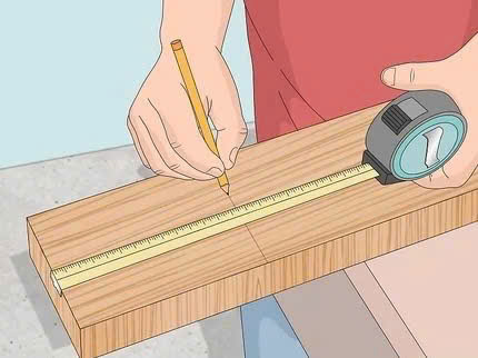 Đánh dấu đường cắt trên gỗ bằng bút chì trước khi sử dụng cưa tay Stanley.